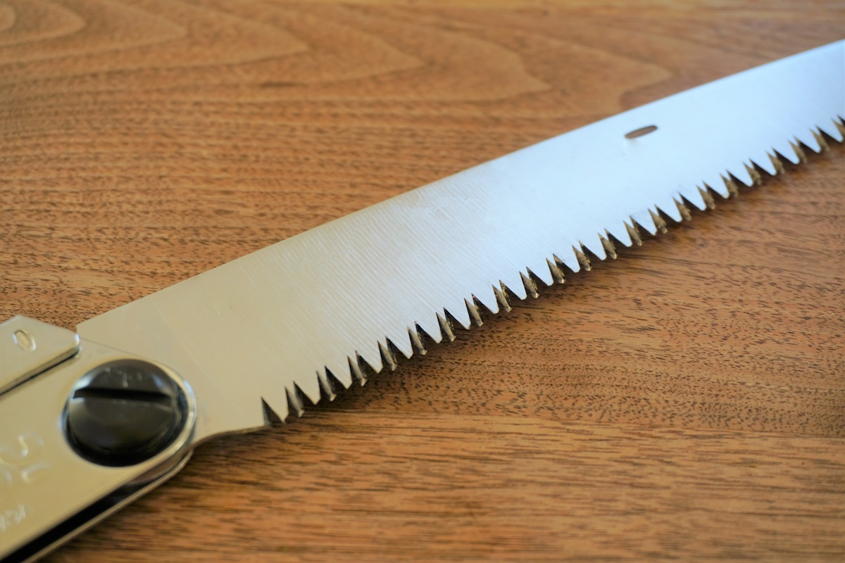 生木の枝を剪定鋸で切っている剪定作業の様子